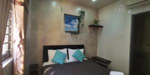 - une chambre avec un lit doté d'oreillers bleus et blancs dans l'établissement Cola's Homestay, à Hô-Chi-Minh-Ville