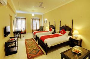 Habitación de hotel con 2 camas y mesa en The Hadoti Palace, Bundi, en Bundi
