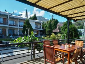a wooden table and chairs on a balcony at Hotel Pondok Asri Tawangmangu in Tawangmangu