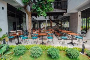 a patio with tables and chairs in a building at Catba Buffalo Hostel in Cat Ba