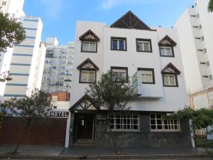 a white building with windows and a door at Hotel Raglan in Mar del Plata