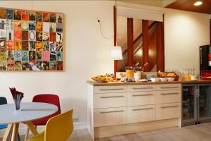 une cuisine avec un comptoir et une table avec des chaises dans l'établissement Hotel The Neighbour's Magnolia, à Amsterdam