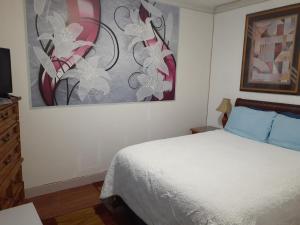 a bedroom with a bed and a painting on the wall at Chameleon Hotel in Castlegar