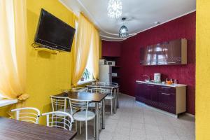 a kitchen with tables and chairs and a tv on the wall at 22-HOTEL in Barnaul