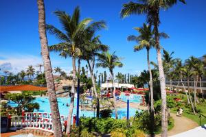 Blick auf einen Pool in einem Resort mit Palmen in der Unterkunft Pacific Islands Club Saipan in Chalan Kanoa