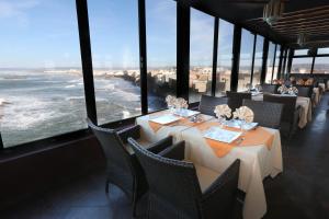 a restaurant with tables and chairs with a view of the ocean at Riad Mimouna in Essaouira