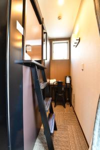 a room with a desk and a stairway at H2O STAY Ōtorii - Male Only in Tokyo
