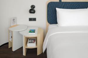 um quarto com uma cama e uma mesa e uma cama sidx sidx em Jasper Young Hotel Banqiao em Taipei