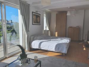 ein Schlafzimmer mit einem Bett und einem großen Fenster in der Unterkunft Apartamenty Orłowo in Gdynia