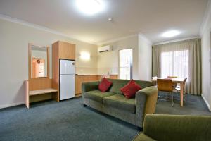 a living room with a couch and a kitchen at Abel Tasman Motor Inn in Dubbo