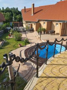 a chain fence with a pool in a yard at Római Apartman in Badacsonytomaj