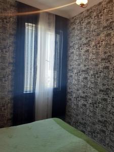 a bedroom with a bed and a window at Guest House Quiet Home in Batumi