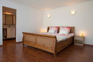 a bedroom with a large wooden bed with two pillows at Sol Aureus in Middelburg
