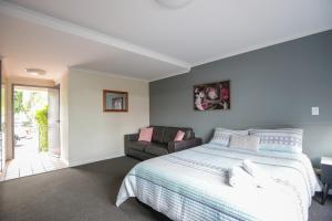 a bedroom with a bed and a couch at Bayview Hotel Woy Woy in Woy Woy