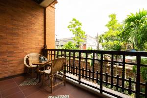 a balcony with a table and chairs on a balcony at Phor Liang Meun Terracotta Arts in Chiang Mai