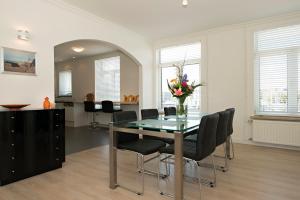 a dining room with a glass table and chairs at Sol Aureus in Middelburg