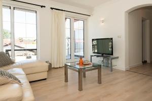 uma sala de estar com um sofá e uma televisão em Sol Aureus em Middelburg