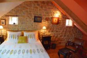 a bedroom with a bed in a stone wall at Chambres d'Hôtes Les Chaufourniers in Crouay