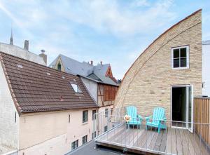 deux chaises bleues sur une terrasse avec un bâtiment dans l'établissement Ferienhaus Grosse 73, Flensburg, à Flensbourg