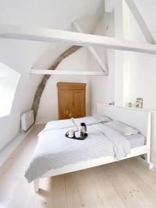 a white bedroom with a bed with a tray on it at Ferienhaus Grosse 73, Flensburg in Flensburg