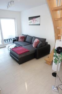 a living room with a black couch in a room at Gästewohnung 16 in Oschersleben