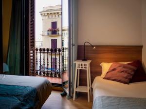 
a bedroom with a bed and a dresser at Pension Ciudadela in Barcelona
