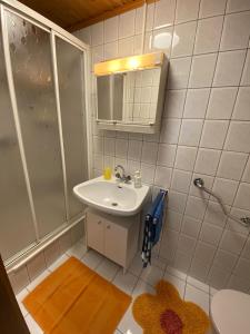 a white bathroom with a sink and a shower at Gasthaus Zum Stadtwald in Rottenmann