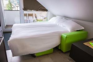 a bed with a green stool in a room at Apartma Mic *** in Kranjska Gora