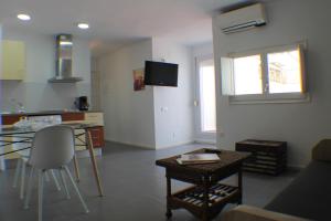 a living room with a table and a kitchen at Agi Peater Center in Roses