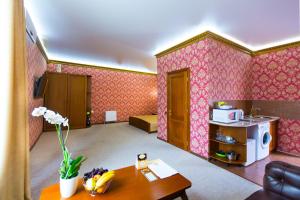 a living room with pink wallpaper and a table at Apart Hotel Clumba in Odesa