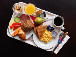 einen Teller mit Frühstückslebensmitteln und eine Tasse Kaffee in der Unterkunft Cabinn Metro in Kopenhagen