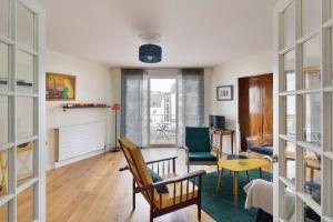 Una sala de estar con una silla y una mesa. en Le Singulier - 2 chambres et parking, en Nantes