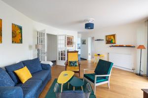 - un salon avec un canapé bleu et des chaises dans l'établissement Le Singulier - 2 chambres et parking, à Nantes