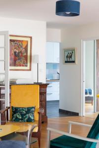 a living room with a yellow chair and a table at Le Singulier - 2 chambres et parking in Nantes