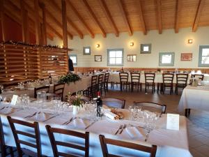 a dining room with tables and chairs with white tablecloths at Certosa 1515 in Avigliana