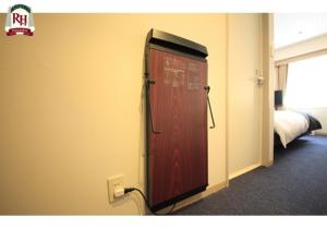 a red door in a room with a bed at Richmond Hotel Tokyo Shiba in Tokyo