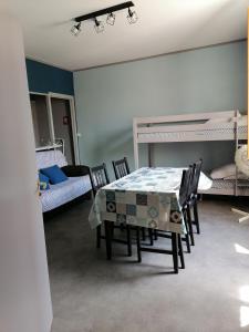 Pokój ze stołem, krzesłami i łóżkami piętrowymi w obiekcie Les Studios proche du Mont Ventoux w mieście Mazan