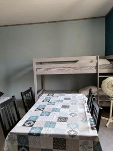 ein Esszimmer mit einem Tisch und einem Etagenbett in der Unterkunft Les Studios proche du Mont Ventoux in Mazan