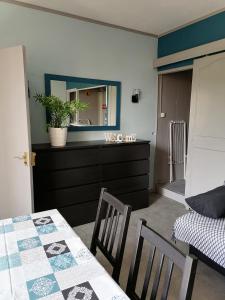 ein Schlafzimmer mit einem Tisch und einer Kommode mit einem Spiegel in der Unterkunft Les Studios proche du Mont Ventoux in Mazan