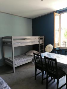 ein Schlafzimmer mit einem Etagenbett, einem Tisch und Stühlen in der Unterkunft Les Studios proche du Mont Ventoux in Mazan