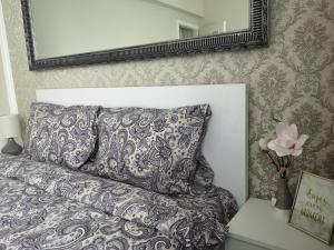 a gray couch with a pillow and a mirror at YNS Apartaments in Iaşi