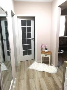 a room with a door and a table with a vase on it at YNS Apartaments in Iaşi