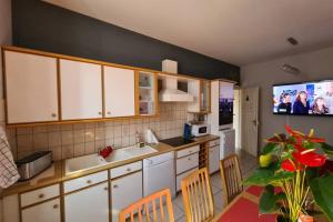 a kitchen with white cabinets and a tv on the wall at la lauch in Colmar
