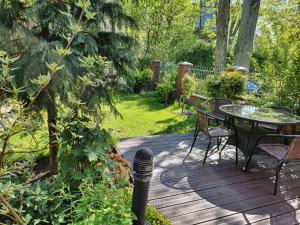 una terraza de madera con mesa y sillas. en Kotedžas prie jūros, en Palanga