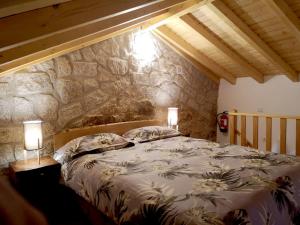 a bedroom with a large bed with two lamps at Casa do Guardado in Monsanto