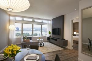 uma sala de estar com uma mesa e uma sala de estar com uma televisão em PARKROYAL Serviced Suites Singapore em Singapura