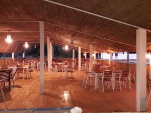 a covered patio with tables and chairs and lights at Samskara-Beach in Călăraşi
