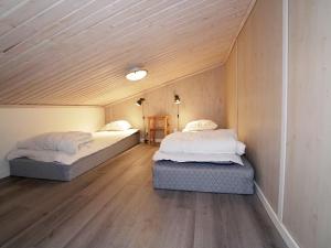 2 letti in una piccola camera con soffitti in legno di Stuga i Järvsöbacken a Järvsö