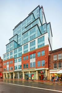 un edificio alto de cristal en una calle de la ciudad en ibis Reading Centre en Reading