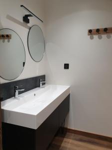 a bathroom with a white sink and two mirrors at Les étoiles de la plagne le Diamant in Mâcot La Plagne +16 photos